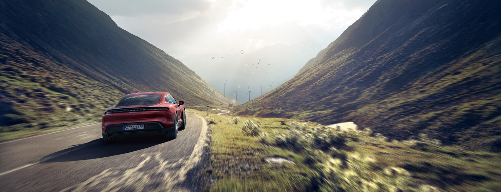 Ein Taycan 4S fährt in der Landschaft.